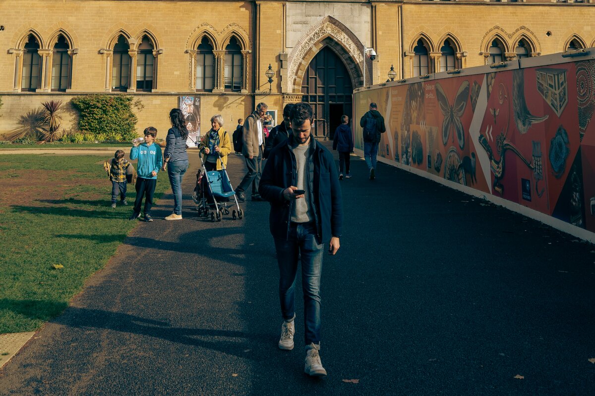 A university building behind students walking down a path 