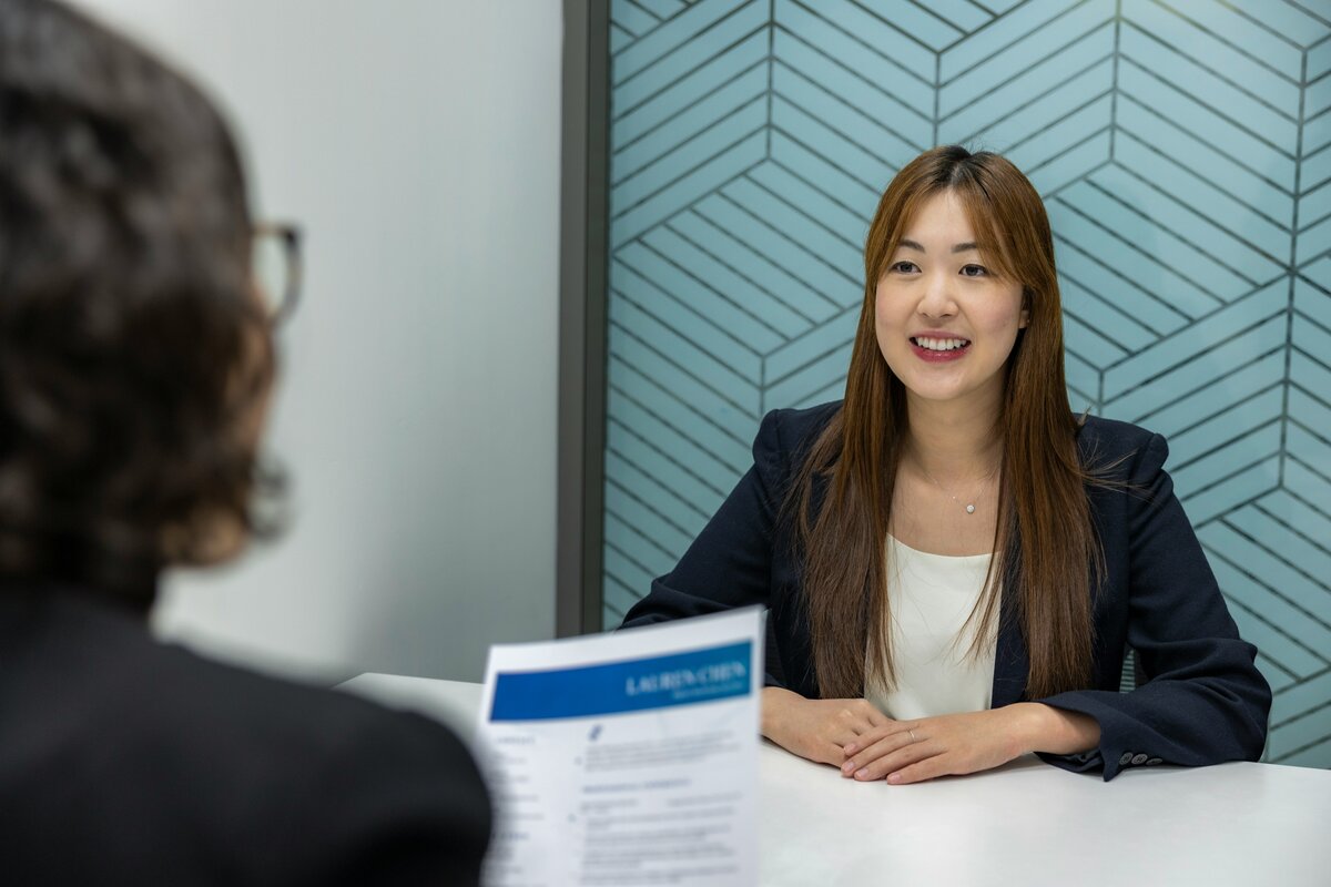 Young woman in job interview with interviewers back to camera