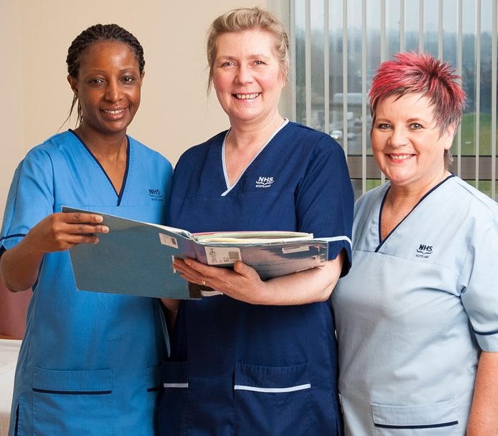Three nurses in NHS Lothian uniforms standing together and smiling